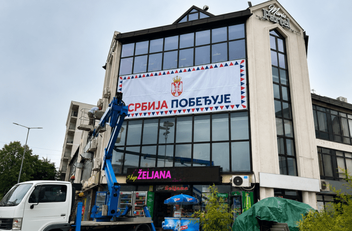Transparent „Srbija pobeđuje“ postavljen na zgradi Tržnog centra Sloboda u centru Inđije.